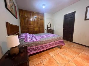 a bedroom with a bed and a table with a lamp at Apartamento Sol Azul a 3 min del Aeropuerto SJO in Alajuela