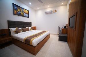 um quarto com uma cama e uma televisão de ecrã plano em Hotel Elite em Amritsar