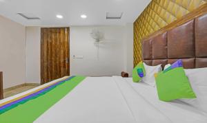 um quarto com uma grande cama branca com almofadas coloridas em Treebo Trend Mona Grand em Nova Deli