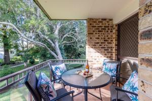 a patio with a table and chairs on a balcony at 30 Bay Parklands in Nelson Bay