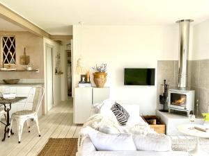 a living room with a white couch and a fireplace at The Tidal Shore - Adults Only - in Marazion