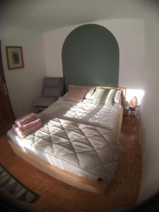 a bedroom with a large bed with an arched headboard at Road View Apartment Celeia in Celje