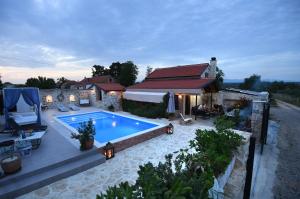 a backyard with a swimming pool and a house at Villa ANTONA in Prkos