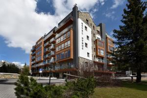 a building with a white and brown at APLEND Hotel Ovruč in Štrbské Pleso