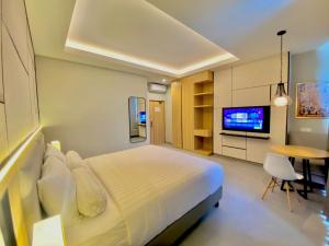 sypialnia z łóżkiem, telewizorem i stołem w obiekcie Front One King Hotel Tuban w mieście Tuban