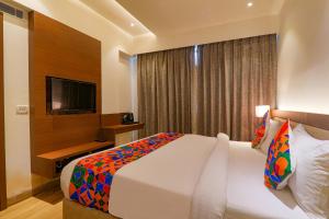 a hotel room with a bed and a television at FabHotel Aurelia Grand in Lucknow