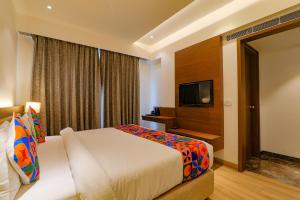 a hotel room with a bed and a flat screen tv at FabHotel Aurelia Grand in Lucknow