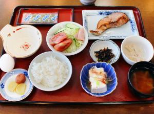 - un plateau de nourriture avec des bols de nourriture sur une table dans l'établissement Hotel Trend Asahikawa, à Asahikawa