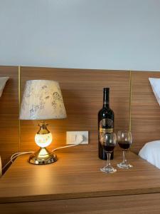 a bottle of wine and two glasses on a table at An Cường Hotel in Sầm Sơn +15 photos