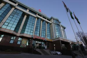 a building with a car parked in front of it at Asia Grand Hotel in Dushanbe