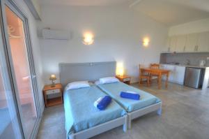 a bedroom with a bed with two blue pillows on it at Paleo Apartments in Paleokastritsa