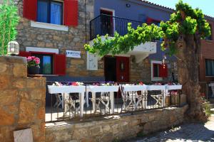 uma mesa com cadeiras em frente a um edifício em PAPARUNA BUTİK OTEL em Gokceada Town