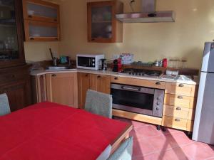 a kitchen with a stove and a microwave at San Berillo house in Catania