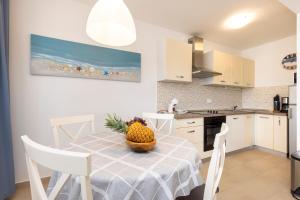 una cocina con una mesa con un bol de fruta. en Apartments Divna en Mali Lošinj