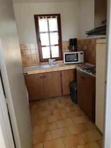 a small kitchen with a microwave and a window at Résidence Lou Cigaloun - ANA LOCATION in Gréoux-les-Bains