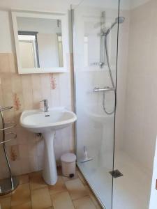 a white bathroom with a sink and a shower at Résidence Lou Cigaloun - ANA LOCATION in Gréoux-les-Bains