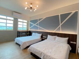1 dormitorio con 2 camas y ventilador de techo en Xiangdao en Sanxing
