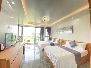 a hotel room with two beds and a flat screen tv at An Cường Hotel in Sầm Sơn