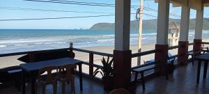 un restaurante con vistas a la playa, mesas y sillas en Vista Aurora en Baler