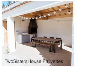 un patio avec une table en bois et une cuisine dans l'établissement Two Sisters House, Private pool & bike storage, Mont-Ventoux, lac Palivettes, Child-friendly, à Malaucène