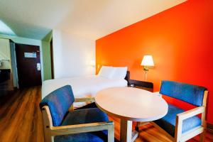 a hotel room with a bed and a table and chairs at Hermiston Inn & Suites in Hermiston