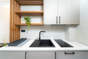 a kitchen with a sink and white cabinets at Acantha Suites in Skala Potamias