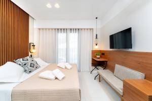 a hotel room with a bed and a television at Acantha Suites in Skala Potamias