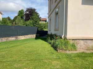 einen Hof neben einem Haus mit einem Zaun in der Unterkunft Gite de Luxe Hautes Vosges Chez Livia in Bruyères