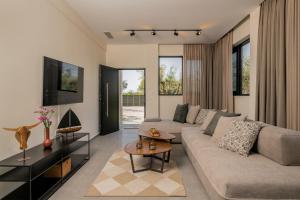 a living room with a couch and a table at Green Herbs Villa in Kalamaki