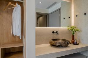 a bathroom with a stone sink and a mirror at Green Herbs Villa in Kalamaki +20 photos