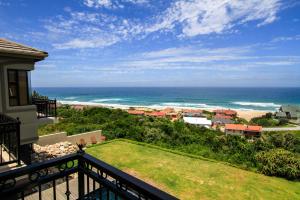 a view of the ocean from the balcony of a house at Two Sunsets B&B in Outeniqua Strand