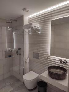 y baño con lavabo, aseo y ducha. en Hotel Paraktio, en Nea Kalikratia