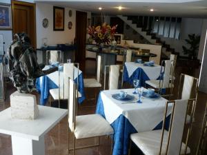 a dining room with white tables and chairs and a staircase at B&B Cà d'Artisti in Caorle