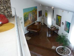 a living room with a piano and paintings on the walls at B&B Cà d'Artisti in Caorle
