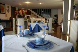 a table with blue and white plates and glasses on it at B&B Cà d'Artisti in Caorle