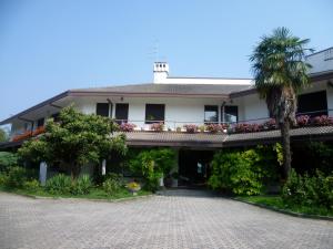 a house with a palm tree and a driveway at B&B Cà d'Artisti in Caorle