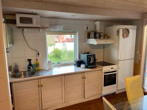 a small kitchen with a sink and a refrigerator at puhkemajake in Rõuge