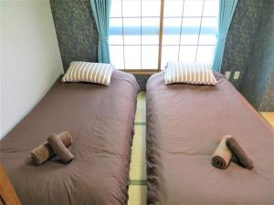 two beds sitting next to each other in a room at 札幌市中心部大通公園まで徒歩十分観光移動に便利なロケーションh208 in Sapporo