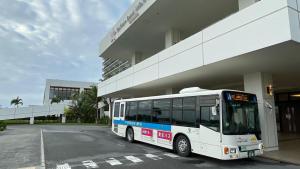 糸満市にあるサザンビーチホテル＆リゾート沖縄の建物の前に駐車した白いバス