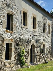 un antiguo edificio de piedra con ventanas y una cámara en Domaine de Kerdavid - Chambres d'hôtes à Remungol, en Évellys