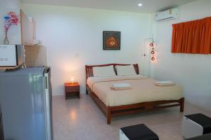 Heaven Beach Koh Samui في Laem Sor: غرفة نوم بسرير وثلاجة