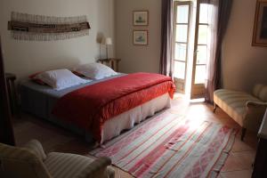 ベジエにあるDomaine de Manteau-Bleuのベッドルーム1室(赤い毛布付きのベッド1台付)