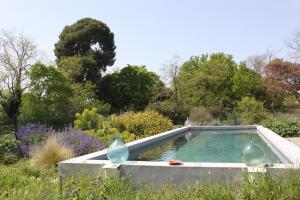 a swimming pool in the middle of a garden at Domaine de Manteau-Bleu in Béziers