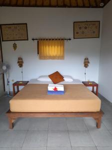 a large bed in a room with two tables at Giri Carik in Sidemen