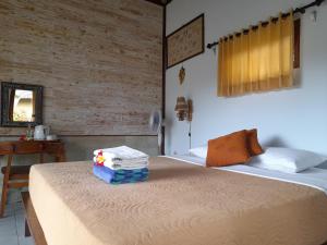 Cette chambre comprend deux lits et une table avec un lit. dans l'établissement Giri Carik, à Sidemen