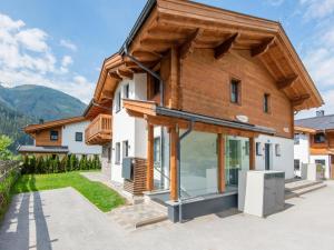 una casa en las montañas con ventanas de cristal en Holiday home in Niedernsill with sauna, en Niedernsill