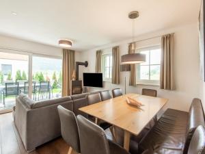 a living room with a couch and a table and chairs at Luxurious holiday home with sauna in Niedernsill Salzburgerland in Niedernsill