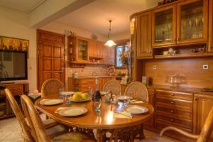 cocina con mesa de madera con sillas y comedor en Villa Elena Crete, en Viranepiskopí