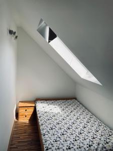 a small bedroom with a bed and a skylight at Domek u Danusi in Lubiatowo