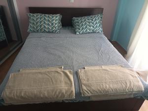 uma cama com duas almofadas e dois cobertores em Evangelli Apartment- An oasis inside the center of Athens em Atenas